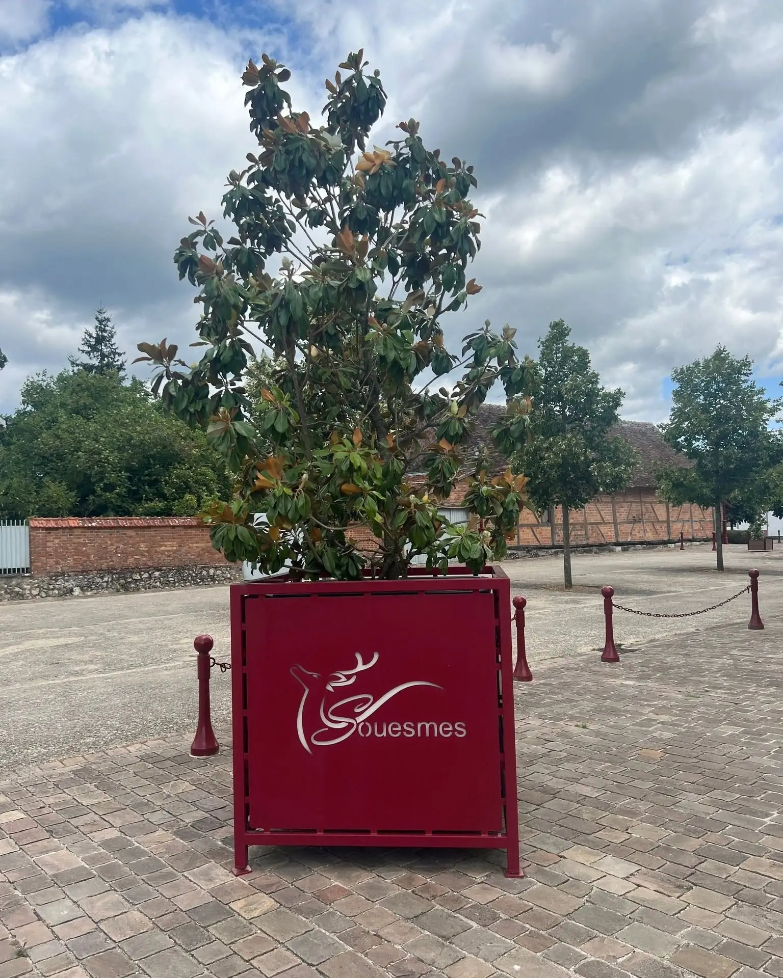 Jardinière métallique rouge au logo au cerf de la commune de Souesmes, découpé au laser