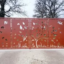 Portail en acier à découpe décorative représentant des motifs végétaux et animaliers
