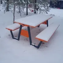 Table de pique-nique orange et blanche photographiée sous la neige